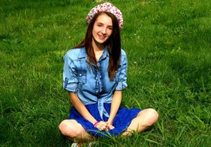 Smiling girl sitting in grass Huntsville Orthodontist